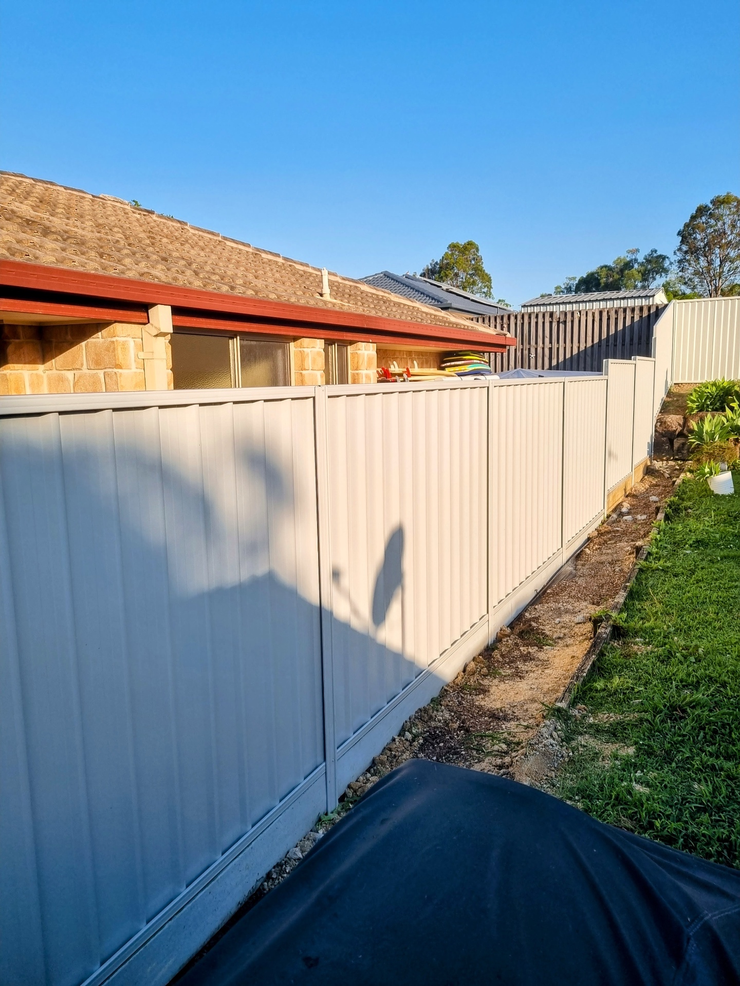 Cream Colorbond boundary fence installed by Ridgeback Fences with clean panel lines and level base.